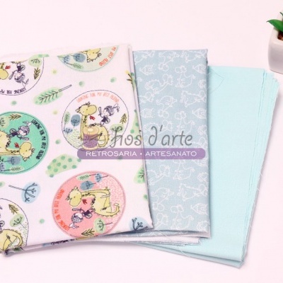 Três panos de tecido com padrões coloridos e um vaso branco com planta suculenta