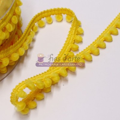 Fitas amarelas com pompons decorativos em tecido sobre superfície branca com logótipo e texto