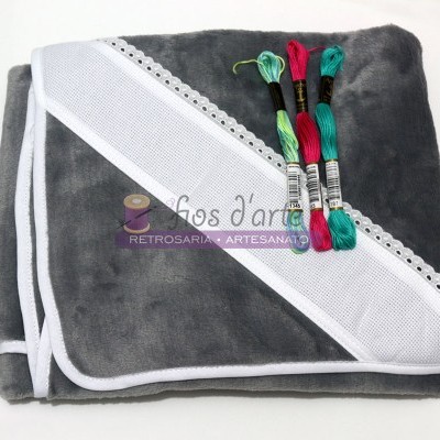 Pacote com manta cinza escura, fita branca para bordado e três novelos de linha colorida