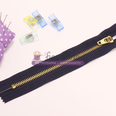 zíper azul escuro com dentes dourados e alfineteiro roxo com bolinhas