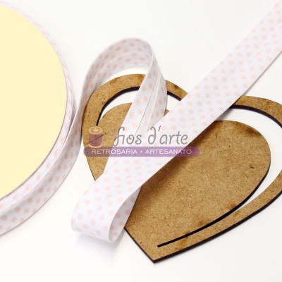 Fita branca com corações cor-de-rosa sobre base de madeira em forma de coração