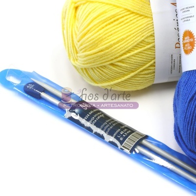 Bolas de lã amarela e azul com etiquetas e agulhas de tricô em embalagem plástica