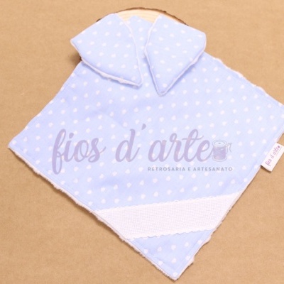 Pano azul claro com corações brancos e faixa branca sobre superfície castanha