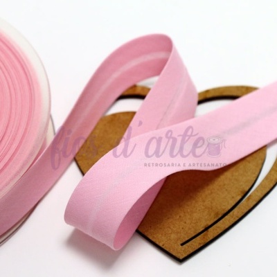 Fita cor-de-rosa enrolada sobre coração de cartão castanho