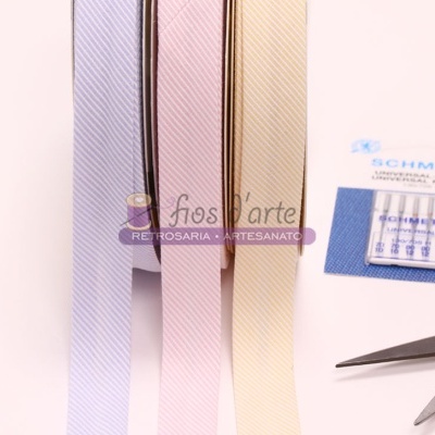 fitas de tecido em tons pastel, agulhas Schmetz e tesoura prateada