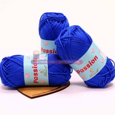 Três novelos de lã azul com rótulo 