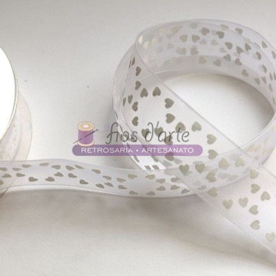 Fita transparente com padrão de corações brancos enrolada junto a uma bobina