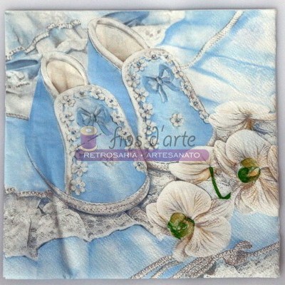 Toalha azul com chinelos bordados e flores brancas ao lado