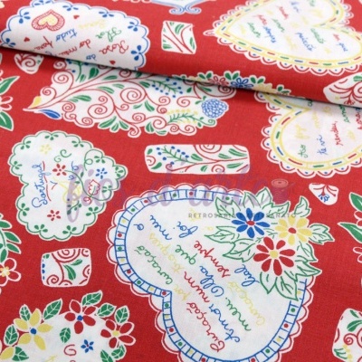 Tecido vermelho com corações brancos decorados e texto colorido em padrão repetitivo