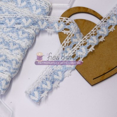 Fita de renda branca e azul enrolada num carretel em forma de coração de madeira