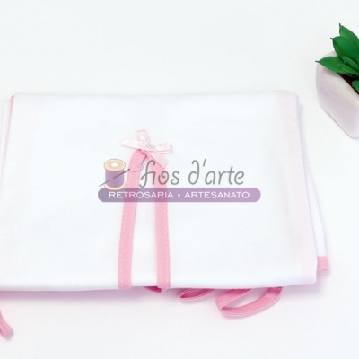 Toalha branca com borda rosa e planta num vaso branco