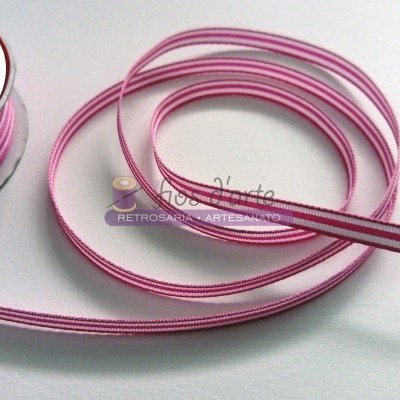 Fita decorativa rosa com bordas escuras enrolada ao lado de carretel