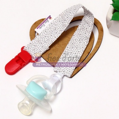 Chupeta azul claro com clip branco e vermelho sobre fundo branco