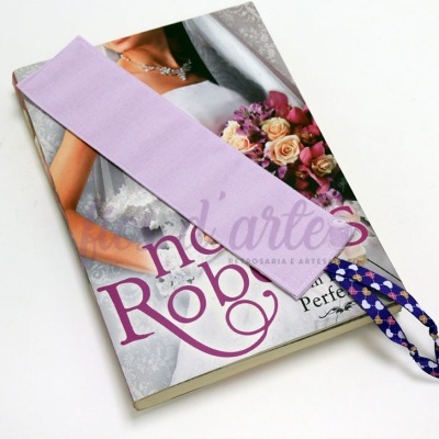 Marcador de páginas lilás em tecido com fita azul e branca sobre revista de noiva