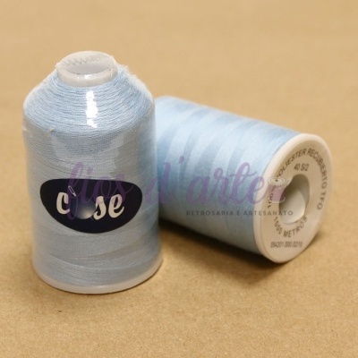 Dois cones de linha de costura azul claro sobre superfície bege