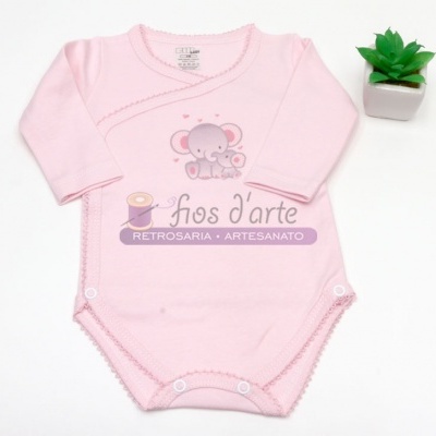 Body de bebé cor-de-rosa com elefante desenhado e planta artificial ao lado