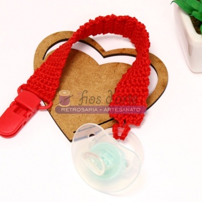 Prendedor de chupeta vermelho com chupeta transparente e cartão castanho em forma de coração