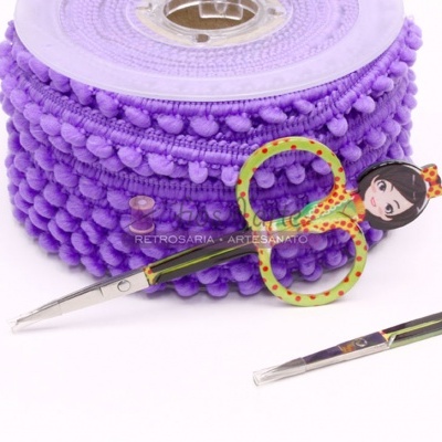 Rolo de fita pompom roxa e tesoura decorativa para artesanato