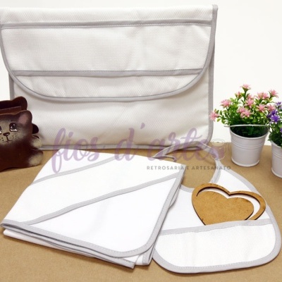 Conjunto branco de tecidos com bordas cinza, acessórios e flores artificiais