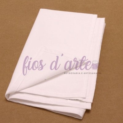 Fralda de tecido branca dobrada sobre superfície castanha