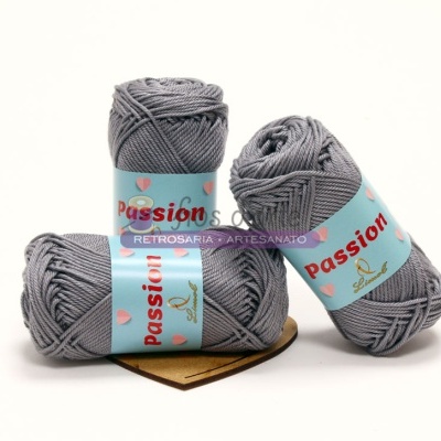 Três novelos de fio cinzento de lã com etiquetas azuis claras e texto 'Passion'