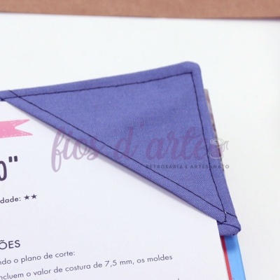 Marcador de página triangular azul em tecido colocado na ponta de uma página