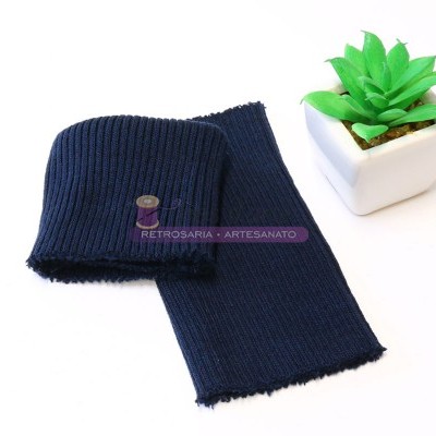 Cachecol de malha azul escuro ao lado de vaso branco com planta verde