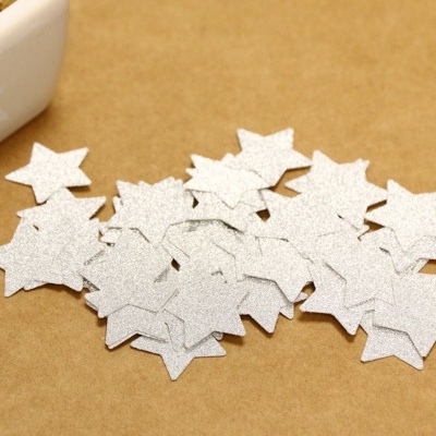Estrelas decorativas prateadas brilhantes sobre superfície castanha