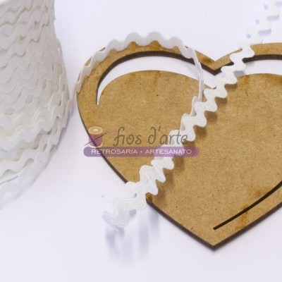 Fitas onduladas brancas e base de madeira em forma de coração com etiqueta artesanal.