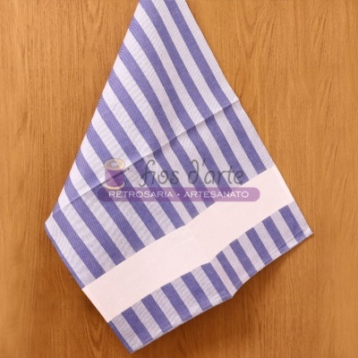 Toalha azul e branca riscada sobre mesa de madeira