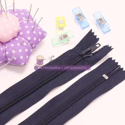 Dois fechos éclair pretos, almofada para alfinetes roxa com bolinhas brancas, alfinetes e clips coloridos para costura