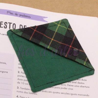 Guardanapo xadrez verde sobre livro aberto com texto em português