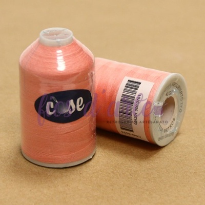 Dois cones de linha cor de pêssego, um em pé com etiqueta 