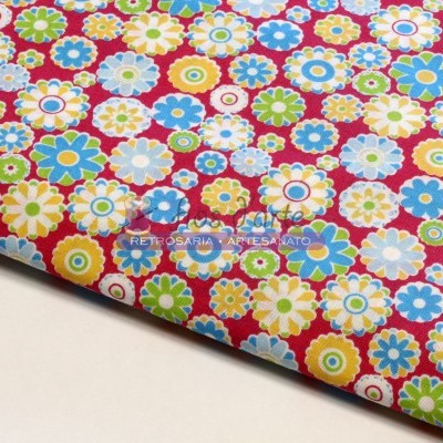 Tecido colorido com padrão de flores multicoloridas sobre fundo vermelho