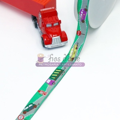Fita decorativa verde com padrão de estrada e carrinhos coloridos perto de carrinho de brinquedo vermelho