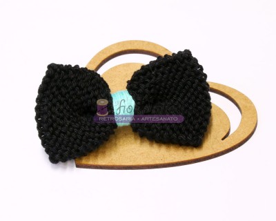 Laço preto de corda trançada em suporte de madeira em forma de coração