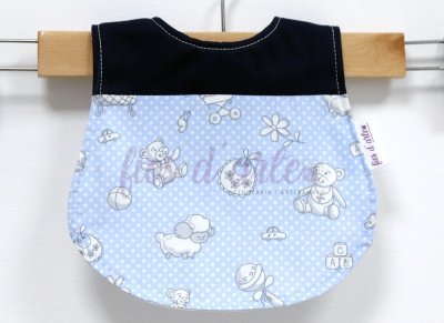 Babete azul claro com padrão de bolinhas brancas e ilustrações de ursinhos e brinquedos, parte superior preta