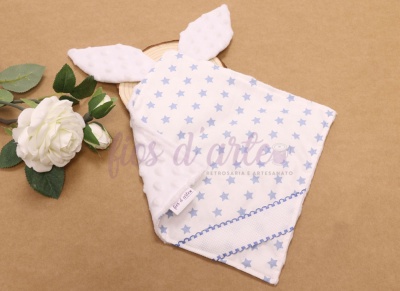 Toalha de rosto com estrelas azuis e orelhas brancas ao lado de flor branca