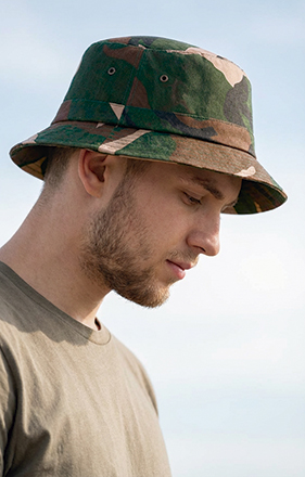 Chapéu bucket camuflado verde, castanho e bege em homem com camiseta bege.