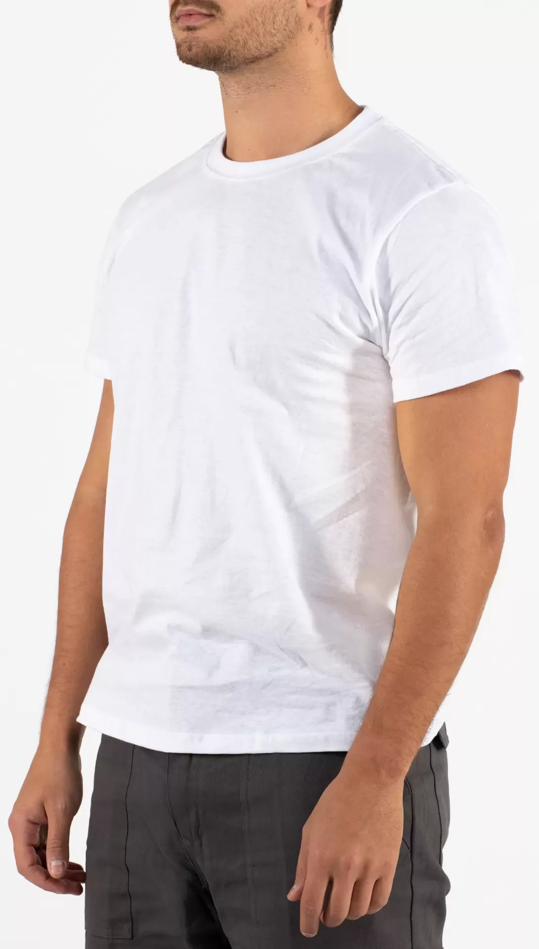 Homem a usar t-shirt branca de manga curta e calças cinza escuras
