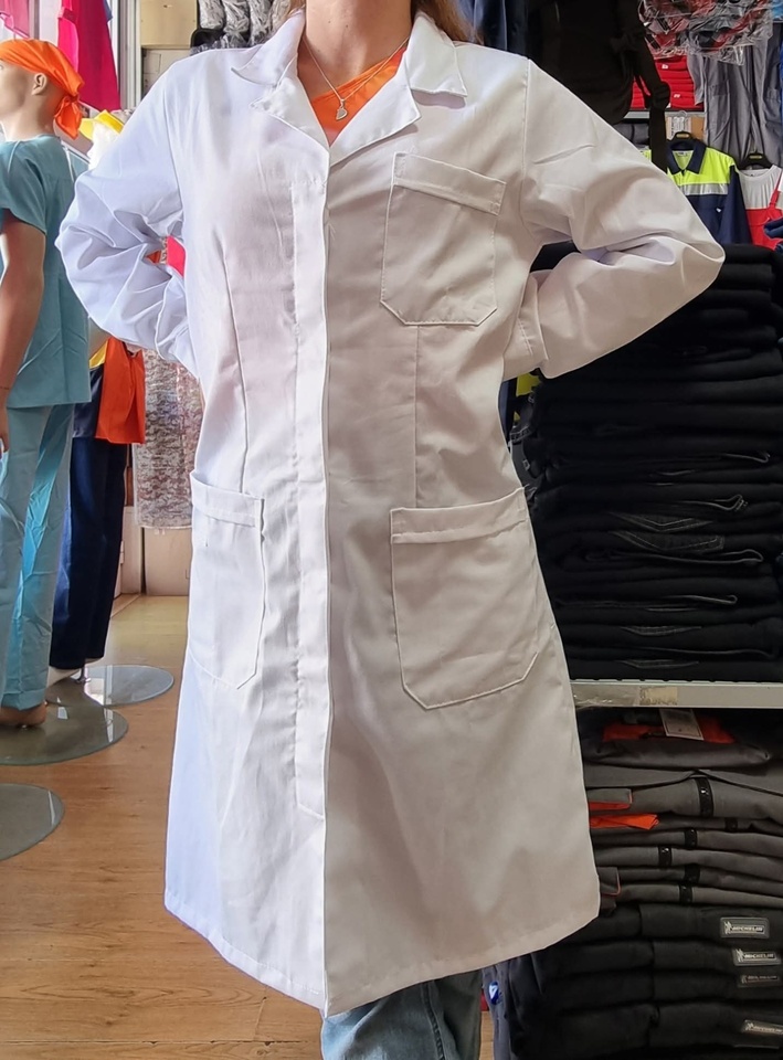 Bata branca longa com três bolsos usada por pessoa em loja com manequins e roupas ao fundo