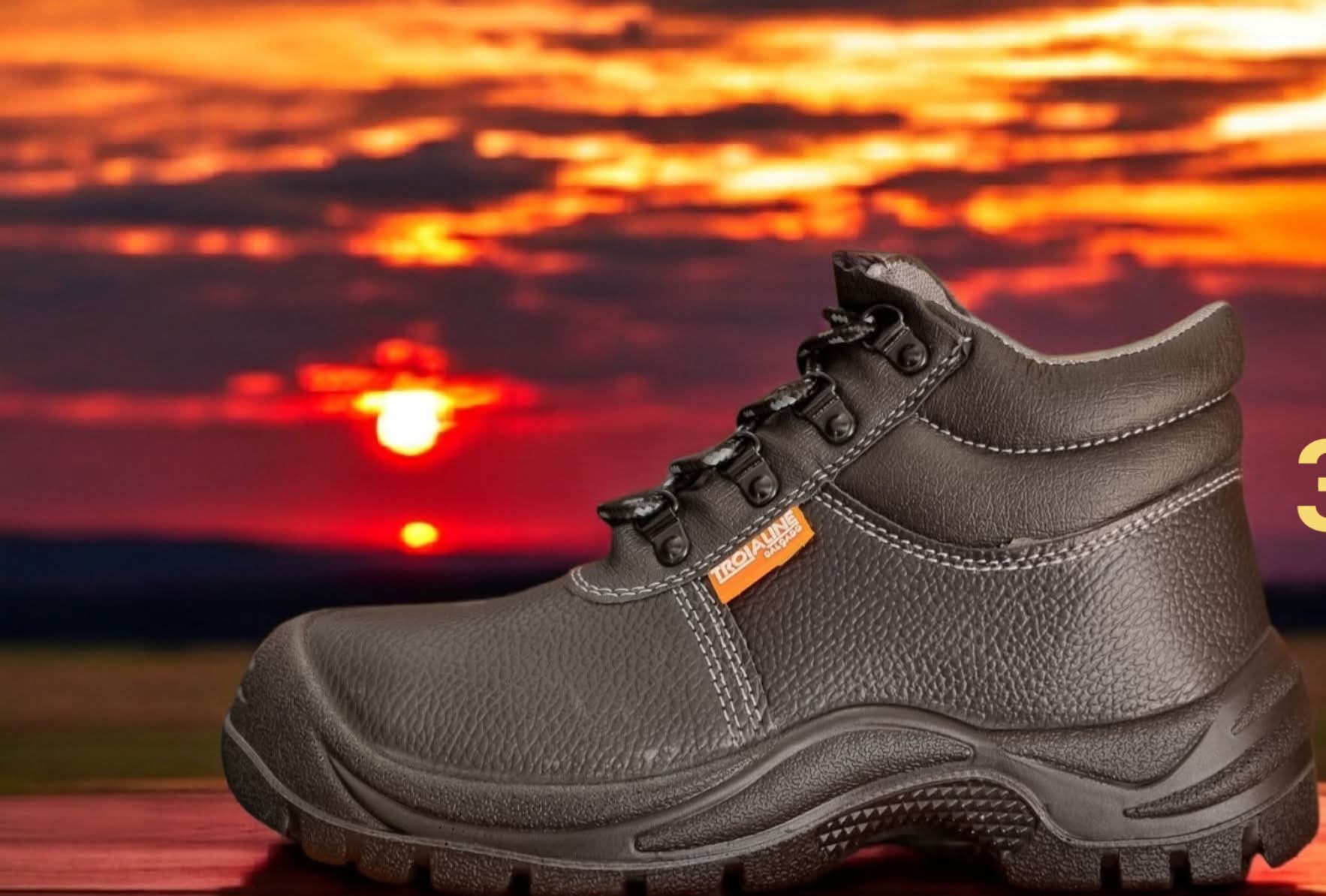 Bota de segurança preta com etiqueta laranja contra pôr do sol
