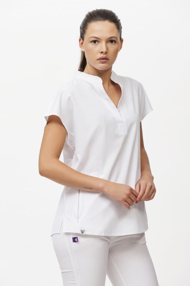 Mulher com blusa branca de gola em V e calças brancas em fundo branco