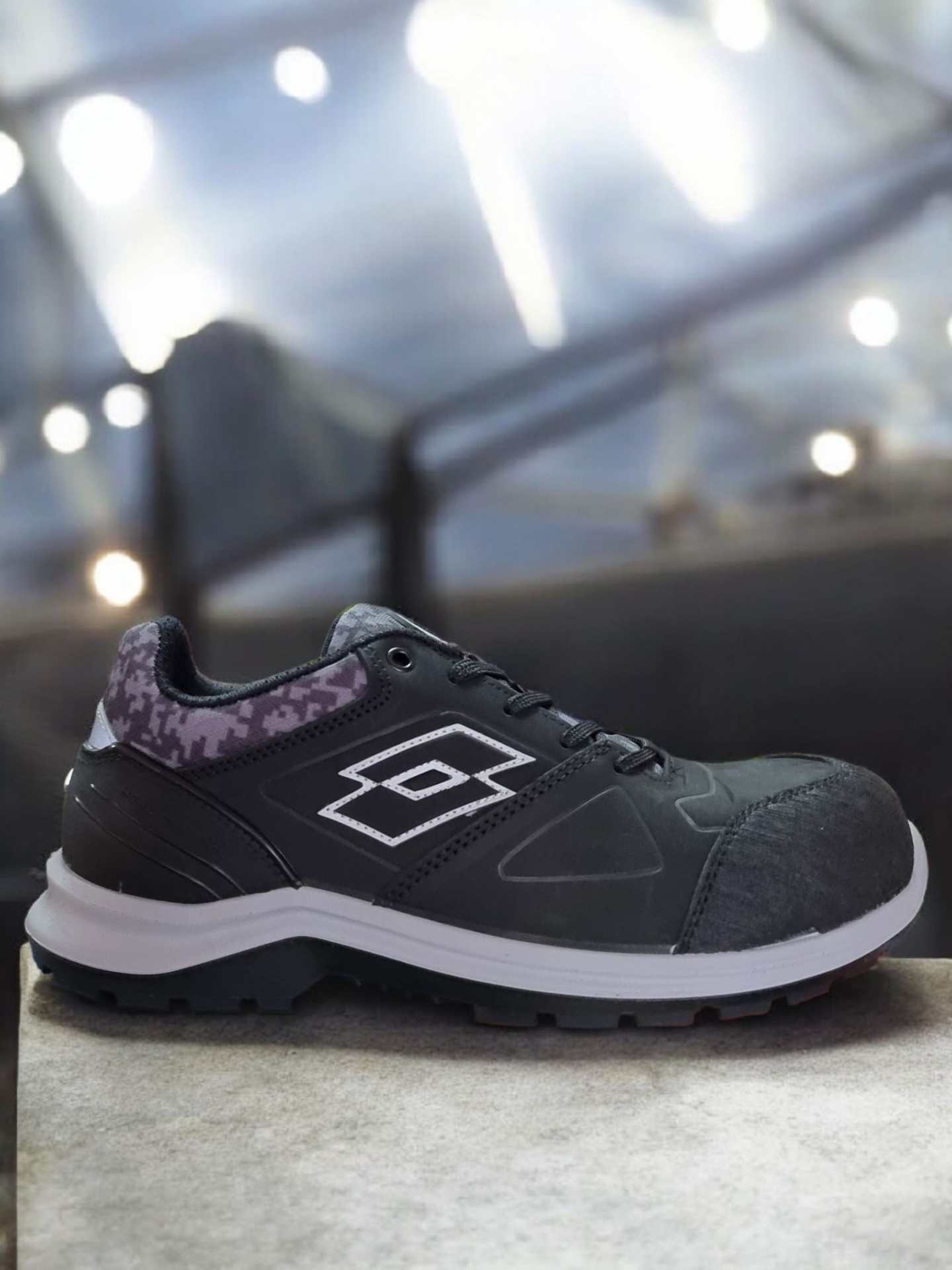 Ténis desportivo preto com sola branca e preta e padrão camuflado roxo no calcanhar