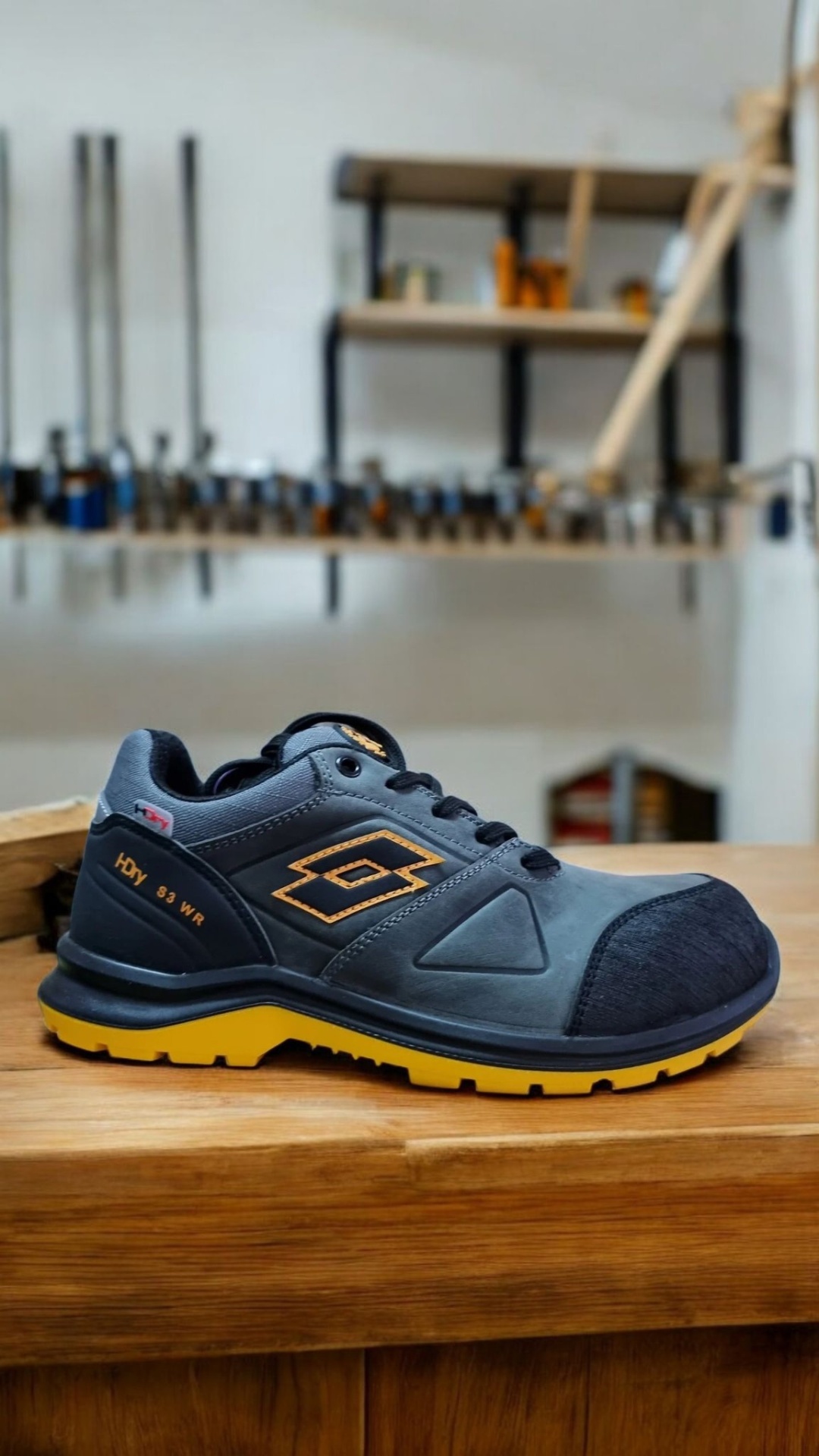 Ténis desportivo cinza e preto com sola amarela e detalhes amarelos