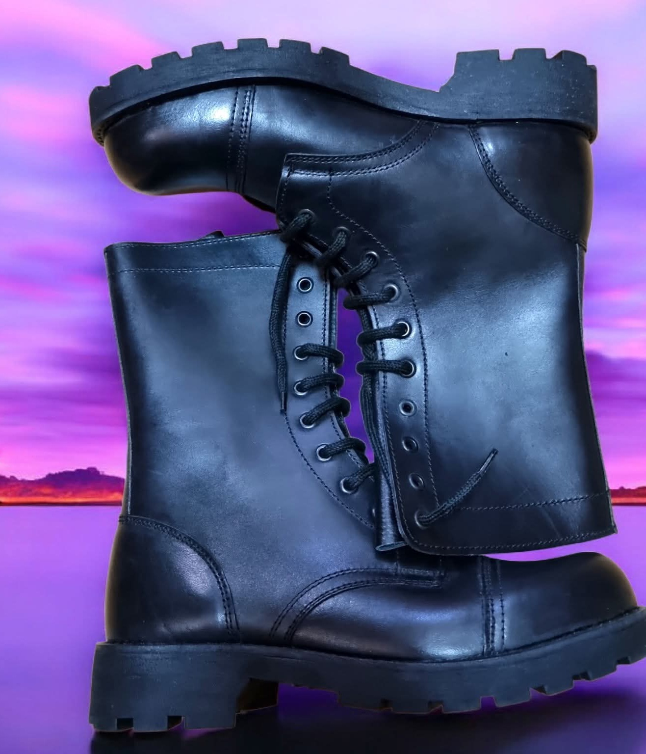 Bota preta de couro com cadarço, sola grossa, contra fundo roxo-rosa