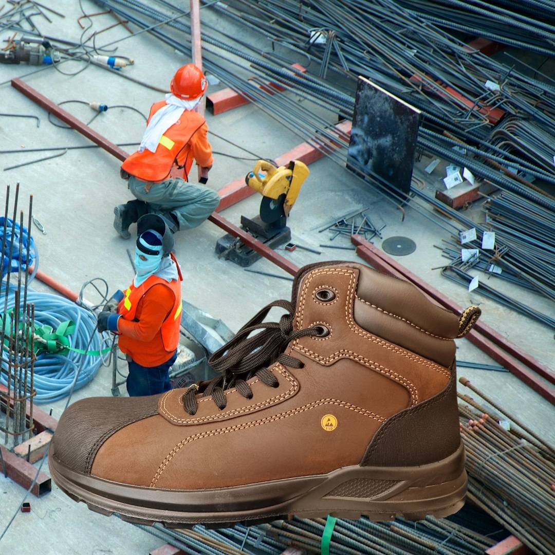 Bota de trabalho castanha com reforço preto na ponta em cenário de obra