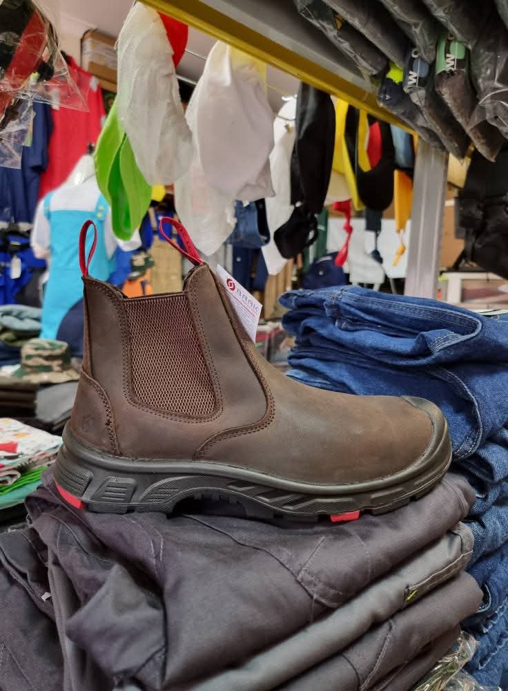 Botim de couro castanho numa pilha de roupas em loja