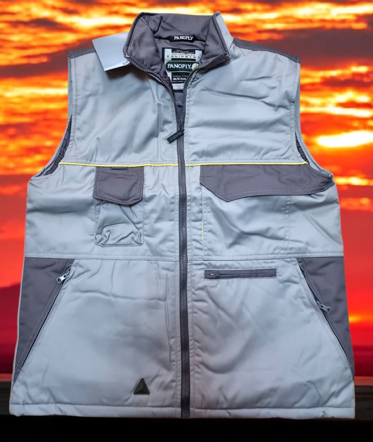 Colete de trabalho cinzento e cinza escuro com vários bolsos e fecho de correr.