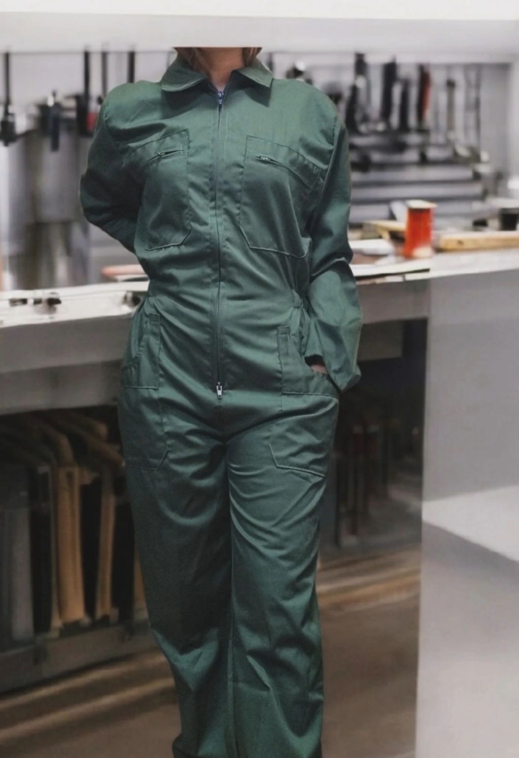 Macacão verde de trabalho com bolsos em ambiente industrial